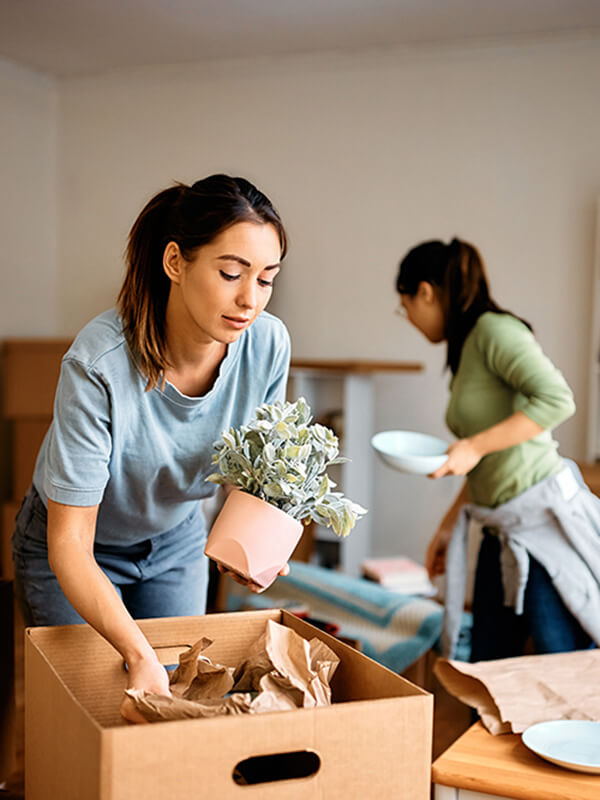 Young woman and her friend packing their belongings 2